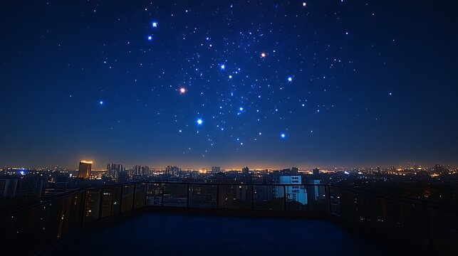 Night city skyline viewed from rooftop balcony under a starry sky.