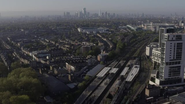 Wide North London aerial with railway, housing, Arsenal Emirates and Highbury stadiums in the foreground and with City of London skyscrapers in the background