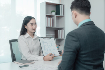 Asian woman doing job interview and sending resume to employee job application concept Job search, candidate submits application documents and resume during job interview in office.