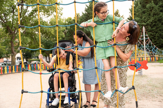 Family supporting disabled children in a joyful park outing