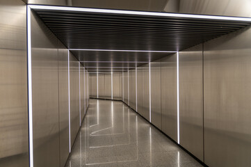Modern metallic corridor with lighting. A minimalist interior featuring geometric lines reflected...