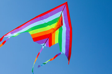 One colorful kite flying in blue sky