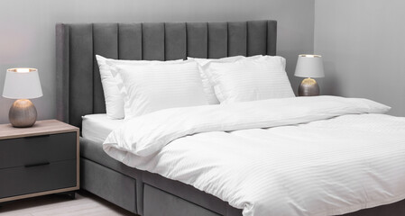 Bed with clean linens and pillows indoors