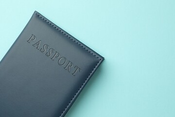 Passport in bright cover on light blue background, top view. Space for text