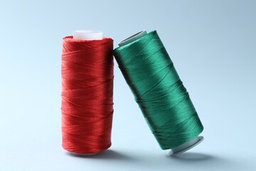 Spools of colorful sewing threads on light background