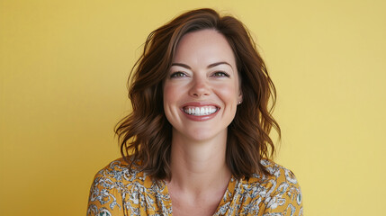 Happy Smiling Woman with Wavy Brown Hair in Yellow Outfit Against Bright Yellow Background
