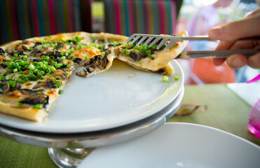 People hands taking slices of pizza. Table with pizza in a restaurant. Pizza and hands close up on a green