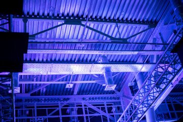 Construction worker cutting steel roof structure