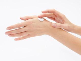 a woman applies a cosmetic product to her hand. Photo on a white background