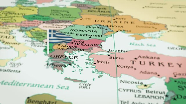 The camera rotating around  Greece, on the world map takes the focus. The Greece flag is waving. Greece flag waving on the map 4K Animation. 