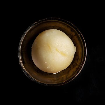 Closeup of a Single Bite Sized Rasagulla Confection on a Black Background