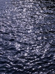 Dark blue ocean glittering water surface at night.
