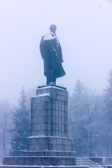 Monument from the Soviet era shrouded in fog and snow on an early winter morning