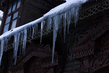 Icicles on an old wooden house in winter