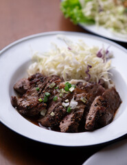 Isaan-style grilled beef, served with a side of fresh herbs and spicy