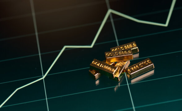 gold bars is on a laptop screen, the laptop screen shows a graph of the gold's price. Concept of wealth and investment