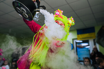 Young girl animator in superhero costume, character shows trick, holding teapot with steam, smoke...