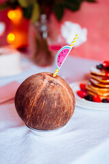 Coconut with a straw on a festive table close-up