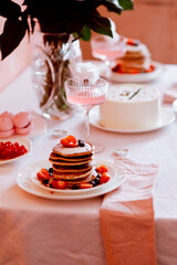 Festive table setting with pancakes, cocktails, cotton candy in pink tones