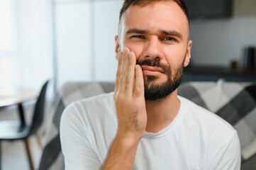 Dental health problems concept. Man suffering from strong toothache. Upset male patient with...