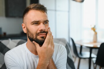 Dental health problems concept. Man suffering from strong toothache. Upset male patient with...
