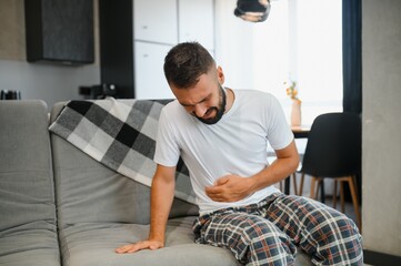 Man suffering from stomach ache at home. Food poisoning
