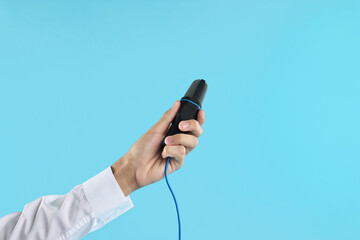 Man with microphone on light blue background, closeup