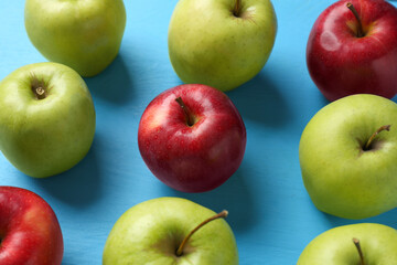 Fresh red and green apples on light blue wooden table
