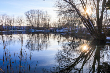 View over the Swan Lake with swans and water birds near Mering on a cold winter's day with a blue sky
