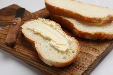 Fresh bread with butter on white table, closeup