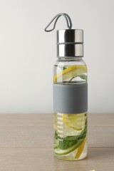 Lemon water with mint in bottle on wooden table