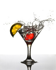 cubito de hielo cayendo en una copa de bebida y un trozo de limon