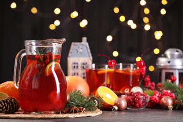 Tasty punch drink and Christmas decor on grey table