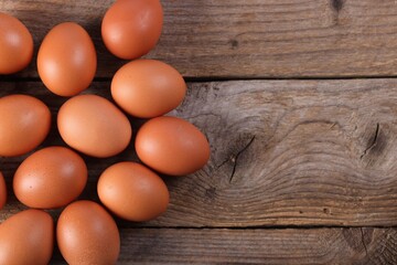 Many fresh eggs on wooden table, flat lay. Space for text
