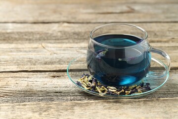 Delicious butterfly pea flower tea on wooden table, space for text