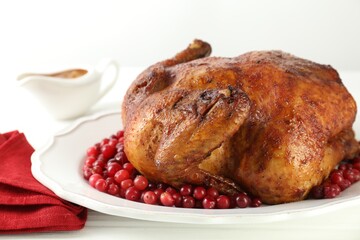 Delicious baked turkey and cranberries on white wooden table, closeup