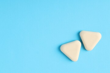 Obraz premium Erasers on light blue background, top view. Space for text