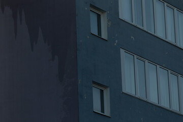 Facade of a residential building with windows, showcasing modern urban design. The architecture reflects functionality and aesthetics, blending seamlessly into the urban landscape.