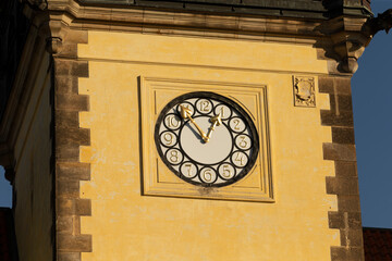 Clock tower on a historic building, showcases a beautifully circular clock face set against a bright yellow wall