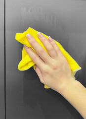 
A woman's hand with a manicure cleans with a damp rag.
Wet cleaning of the house.