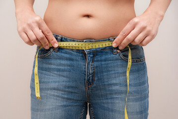 close up of Woman measuring waist with measuring tape for weight loss and dieting control