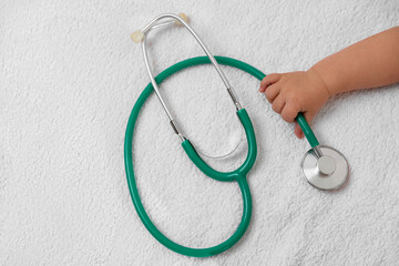 Little child with stethoscope on towel, top view. Checking baby's health