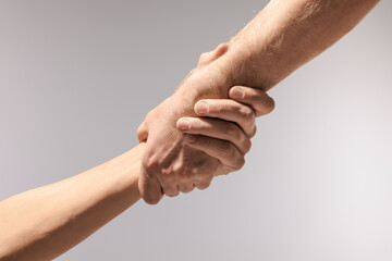 Help and support. People holding hands on light grey background, closeup