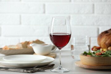 Red wine and delicious dinner served on light table
