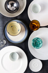 Top view of an empty plates, bowls and glasses placed on a black chalkboard background. Flat lay. Top view. Food concept.