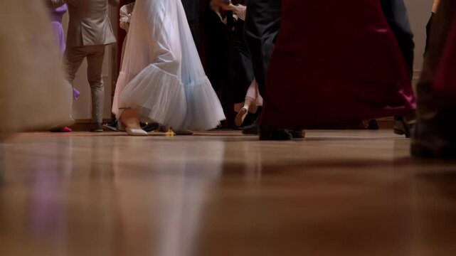 Large ballroom is filled to capacity with people enjoying lively dance party, where couples are skipping to the old-fashioned music.