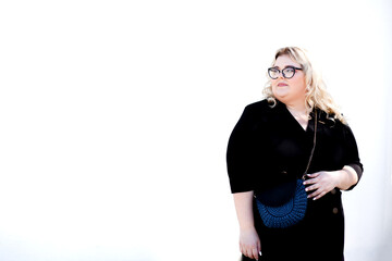 A fat woman wearing a strict dress and glasses is walking in the park