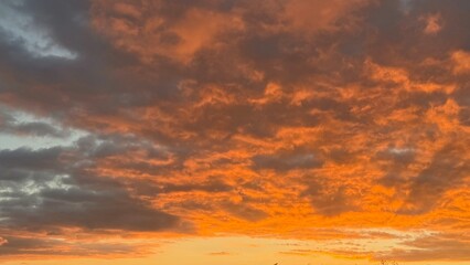 Fototapeta premium Banner of vibrant orange clouds at sunset.