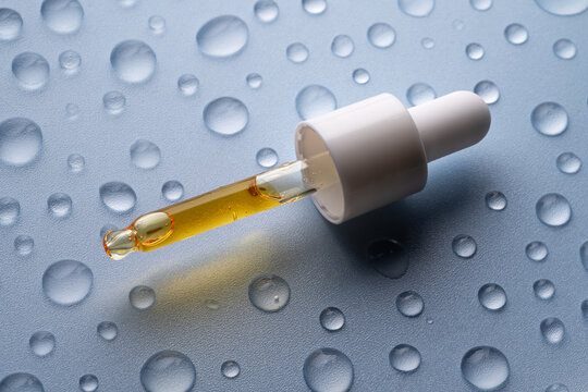 Vitamin C Serum in Pipette with Water Droplets on Surface