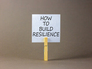 How to build resilience symbol. Concept words How to build resilience on beautiful white paper on clothespin. Beautiful grey background. Business and how to build resilience concept. Copy space